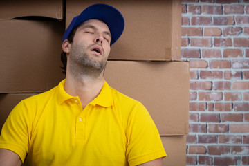 Brazilian mailman sleeping in a deposit with a a lot of boxes.