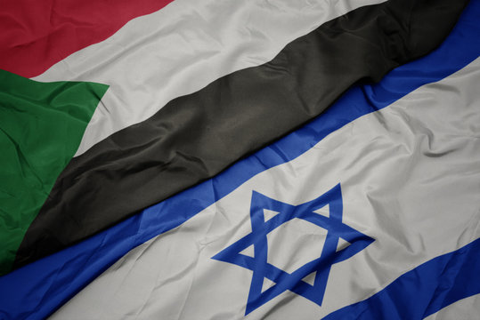 Waving Colorful Flag Of Israel And National Flag Of Sudan.