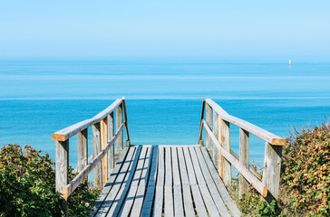 Wooden stairway leading to the beach with crystal clear blue water.