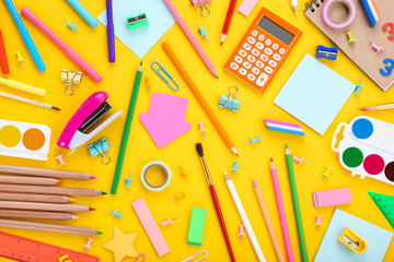 Different school supplies on yellow background