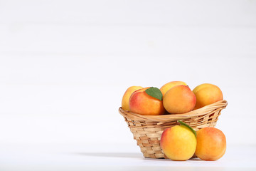 Sweet apricots in basket on white background