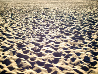 Footprints on the beach sand during sunset, summertime