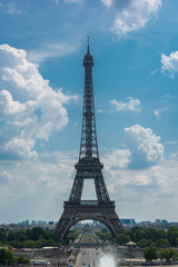 Eiffel tower over a blue cloudy sky