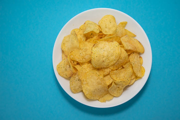 chips in white plate on blue background