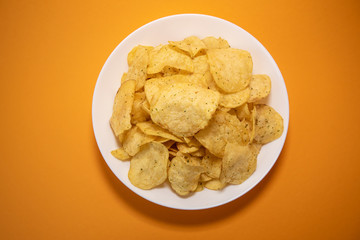chips in white plate on yellow background