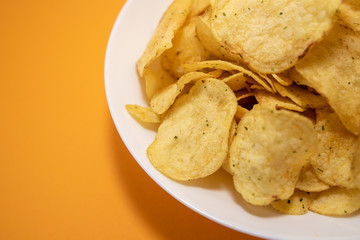 chips in white plate on yellow background