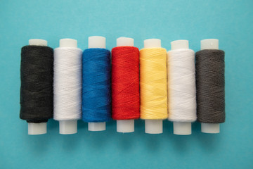 Set of sewing threads beautiful color (blue,yellow, green, white, black) on blue background