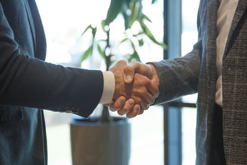 Businessmen shake hands in office