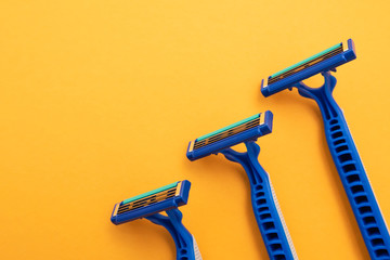 New disposable razor blade, on yellow background, isolated