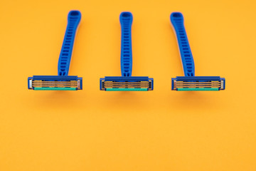 New disposable razor blade, on yellow background, isolated