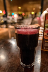 Shallow depth of focus on the froth in a glass of chicha morada served at a Peruvian restaurant