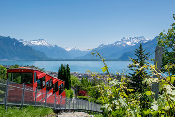 Red cable car on the top of mountain with the view on Lake Geneva and Alps mountains