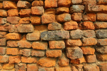 Old orange and red breakable brick arch wall with pattern.
