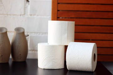 White toilet paper rolls and other home related objects against a white wall. Copy space.