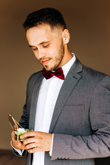 Cute groom looks into a glass box