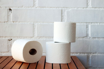 White toilet paper rolls and other home related objects against a white wall. Copy space.