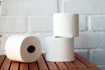 White toilet paper rolls and other home related objects against a white wall. Copy space.