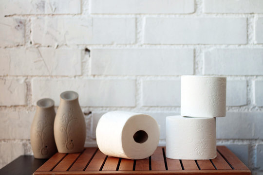 White Toilet Paper Rolls And Other Home Related Objects Against A White Wall. Copy Space.