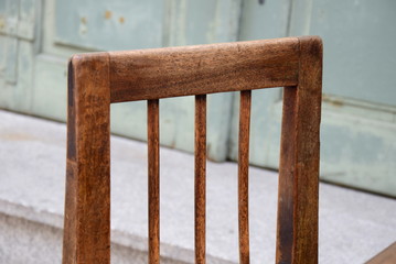 Alter Holzstuhl mit Holztisch vor einem alten renovierten Gasthof