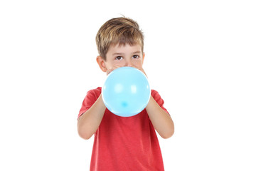 Little boy blowing blue balloon on white background