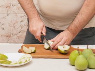Knife cutting green pears on a cutting board
