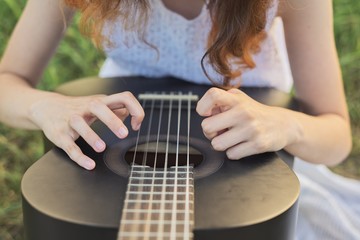 Fototapeta premium Close-up hands fingers of girl playing guitar