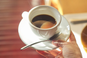 Cup with morning coffee in female hand