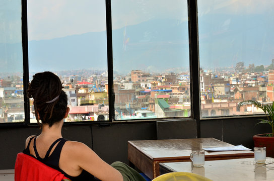 Woman With Dreadlocks Sitting In A Bar Watching Kathmandu City, Nepal