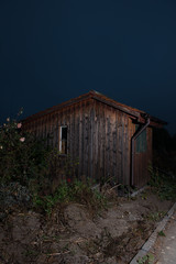 Altes Holzhaus in einem Schrebergarten mit verwittertem Garten im Vordergrund