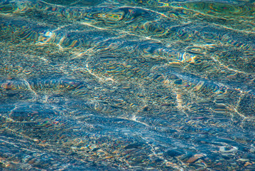 Background of stones in crystal blue water