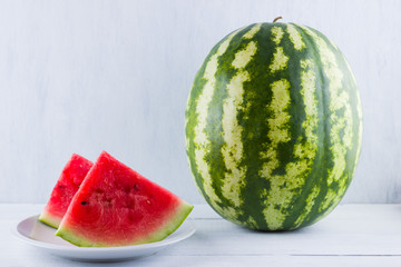 Watermelon on natural white background. Whole watermelon on wooden background. Healthy food for vegan. Copy space