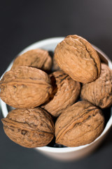 white bucket full of nuts on black background