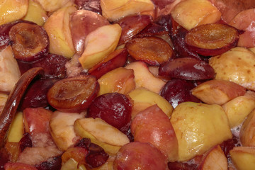 Boiling plum and apple jam. Plum confiture with sugar syrup is cooking in a copper pelvis.