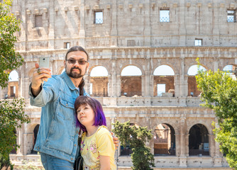 Father and dauther making selfie near Colloseum, Rome, Italy