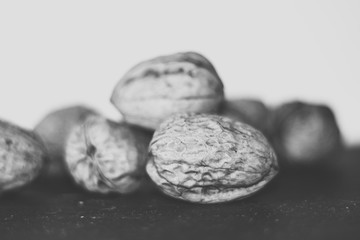 black and white photo walnuts stacked with black background