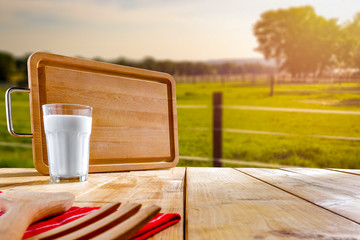 Table background with milk in glass.  Farm background in sunny autumn time.  Space for products, decoration or text.