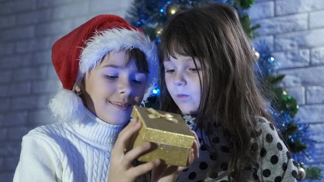 Christmas bright box. Little sisters open a magic Christmas box.