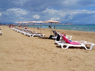 view of sun loungers lined up on a sandy beach in Alicante Spain