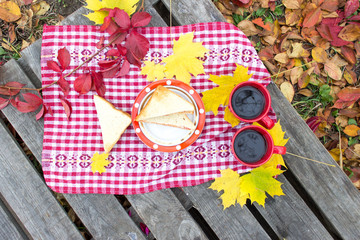 Autumn picnic, red cup with a thermos and sandwiches on a wooden table. Lunch for lovers flat lay