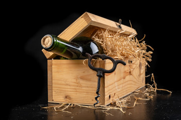A bottle of wine in a wooden box. A tasty alcoholic drink in an elegant package.