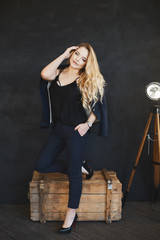 Leggy blonde posing seductively on her wooden desk