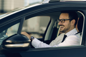 Happy businessman going on a business trip by car