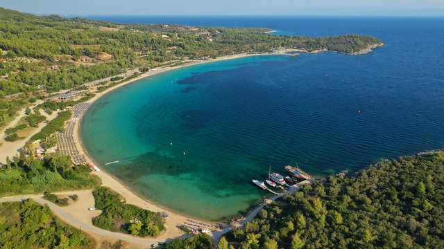 Aerial drone view of iconic sandy turquoise organised with sun beds and umbrellas beach of Paliouri in Kassandra Peninsula, Halkidiki, North Greece
