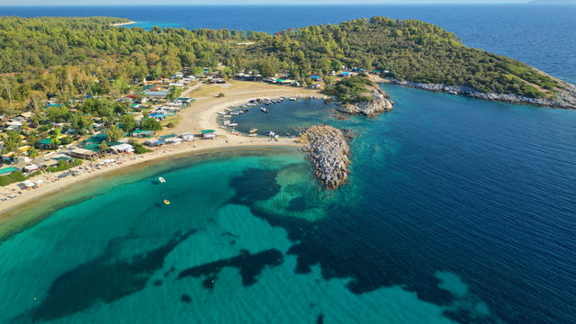 Aerial drone view of iconic sandy turquoise organised with sun beds and umbrellas beach of Paliouri in Kassandra Peninsula, Halkidiki, North Greece