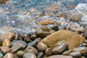 Transparent water splashing on the stones on the shore