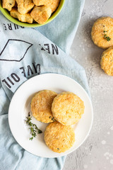 Savory scones or cookies with cheese and thyme on a white ceramic plate. Light grey concrete background. 
