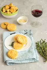 Savory scones or cookies with cheese and thyme on a white ceramic plate. Light grey concrete background. 