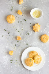 Savory scones or cookies with cheese and thyme on a white ceramic plate. Light grey concrete background. 