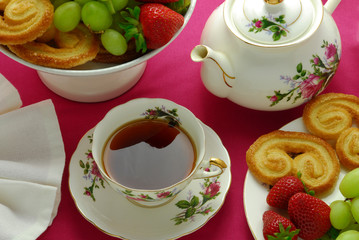 close up of tea cup and tea pot with biscuits, tea time