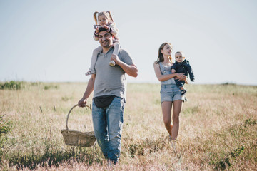 Happy family having fun on sunny meadow.